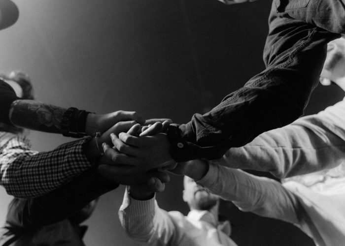 A group of diverse hands united in a gesture of teamwork and collaboration.